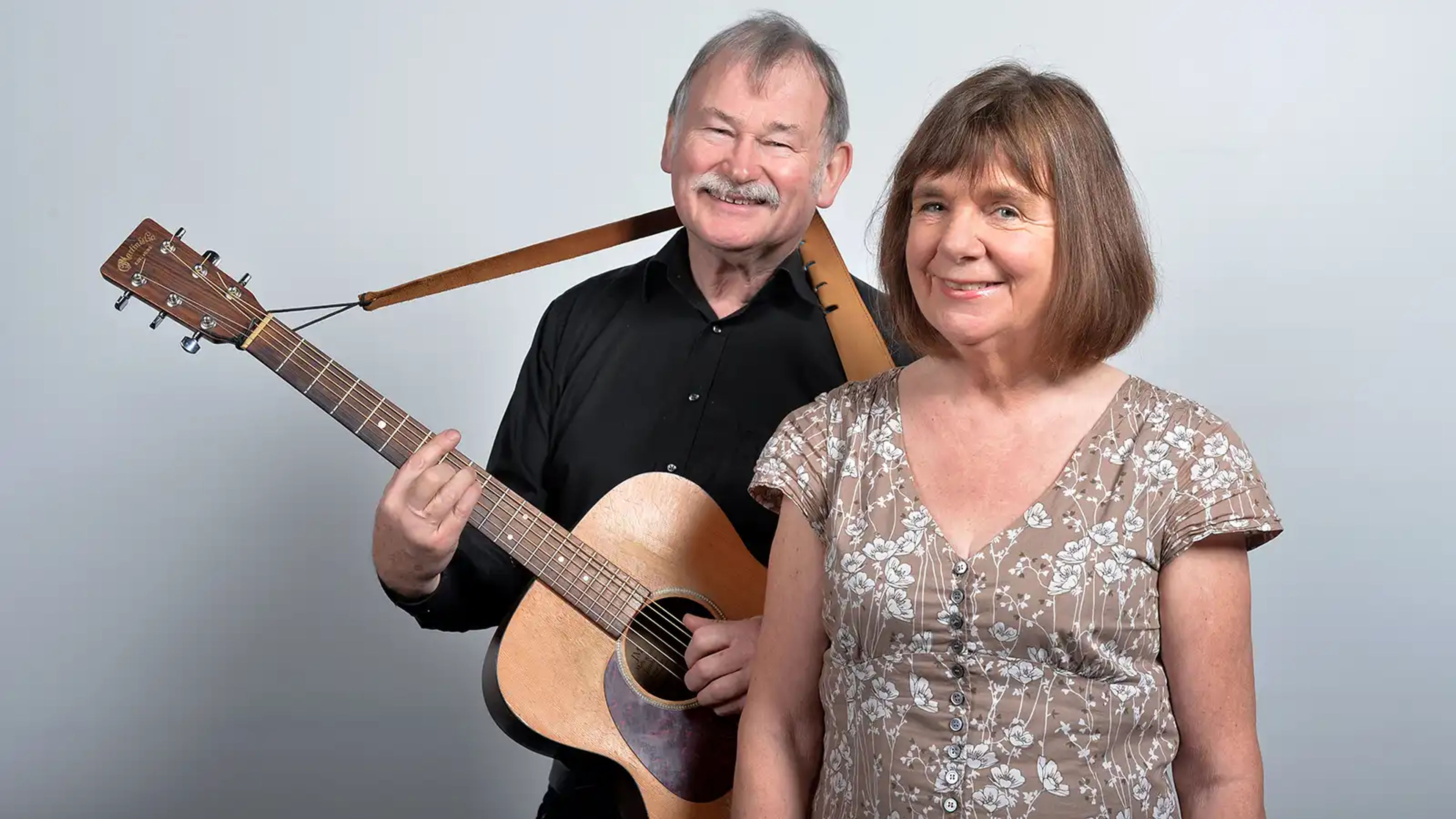 A photograph of Julia Donaldson with Malcolm, who is holding an acoustic guitar