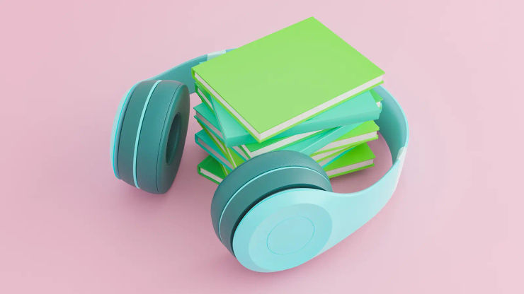 A pair of chunky blue headphones around a pile of books on a pink background