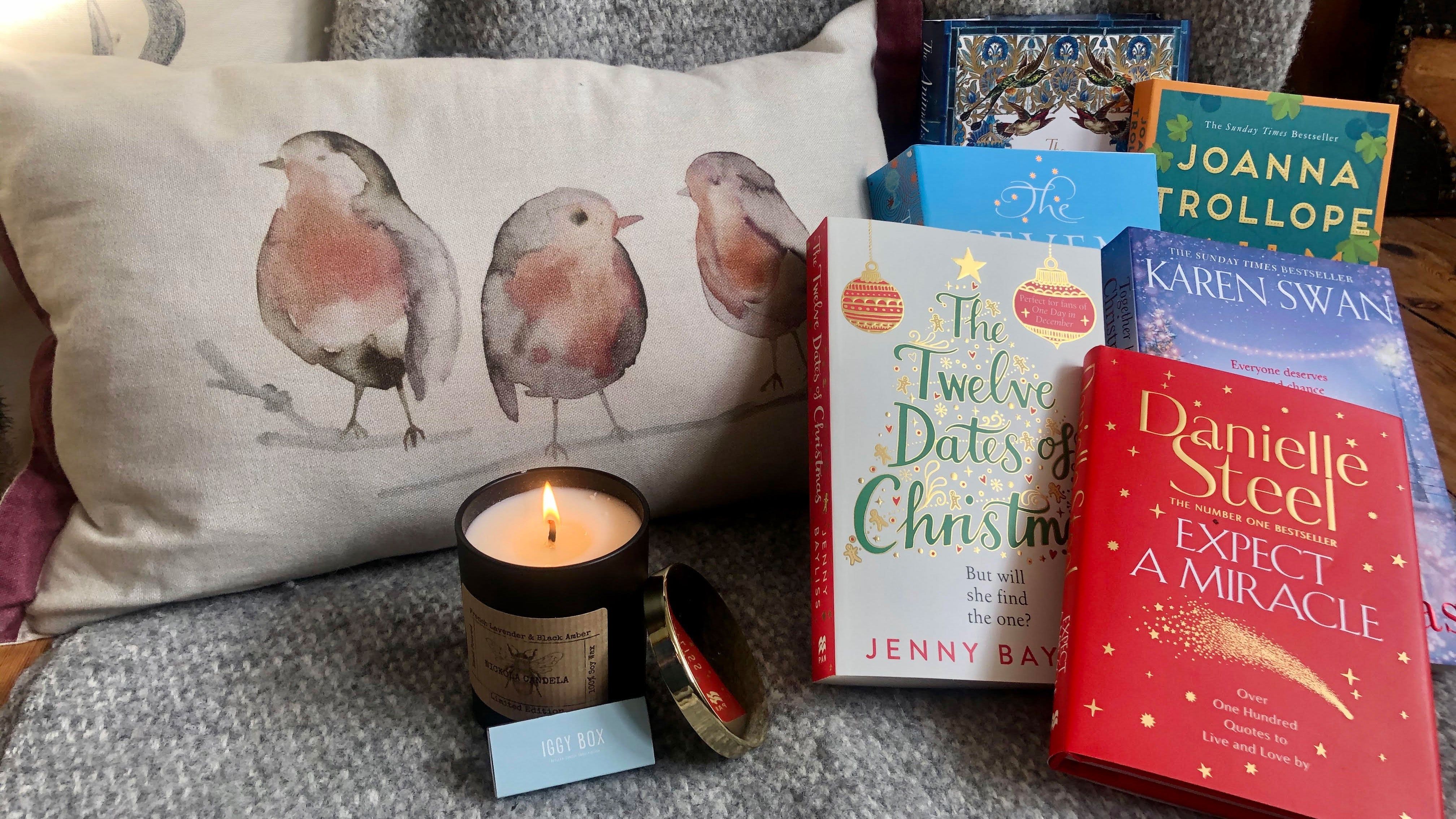 Pile of books next to Iggy Box candle