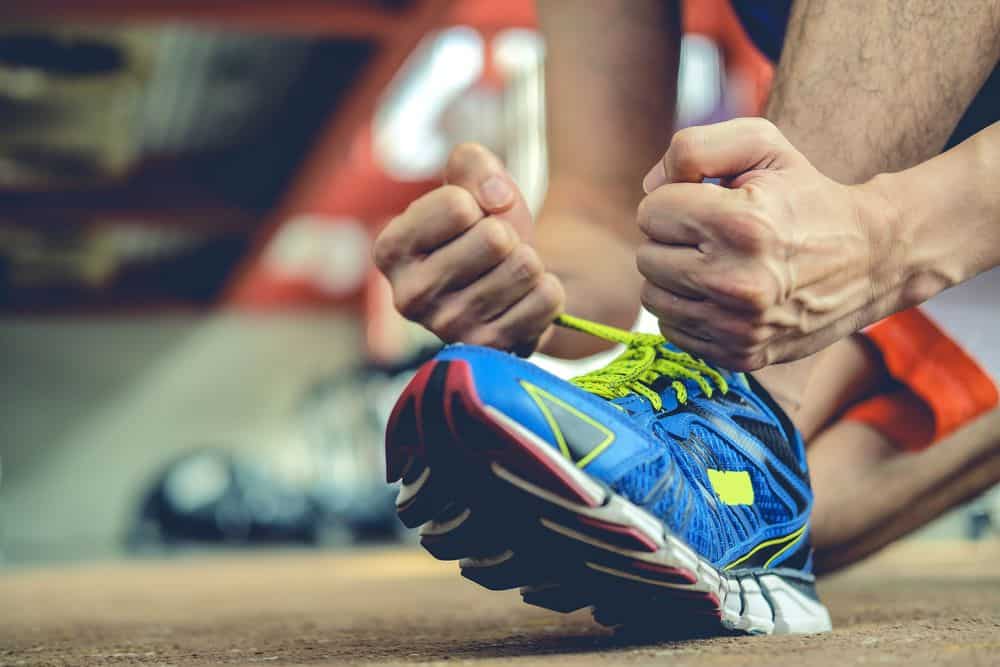 Athlete is tieing his shoelaces running shoes - Running Gear for Beginners Athlete is tieing his shoelaces running shoes - Running Gear for Beginners