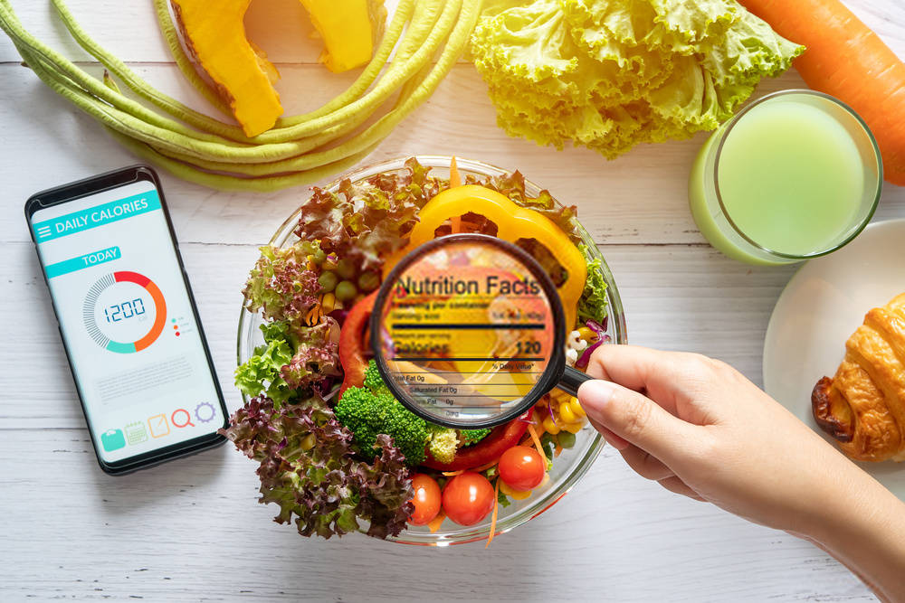 nutritional information concept. hand use the magnifying glass to zoom in to see the details of the nutrition facts from food