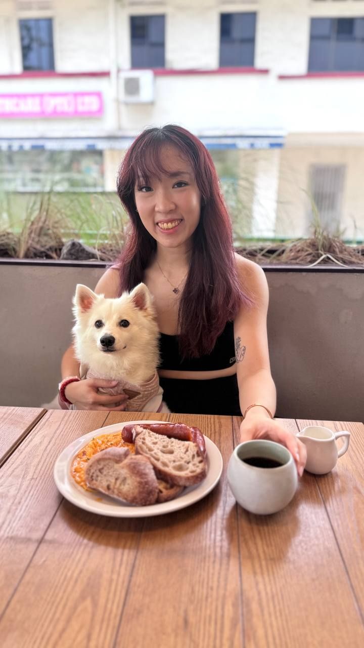 A woman sitting with her Japanese Spitz at a cafe in Singapore