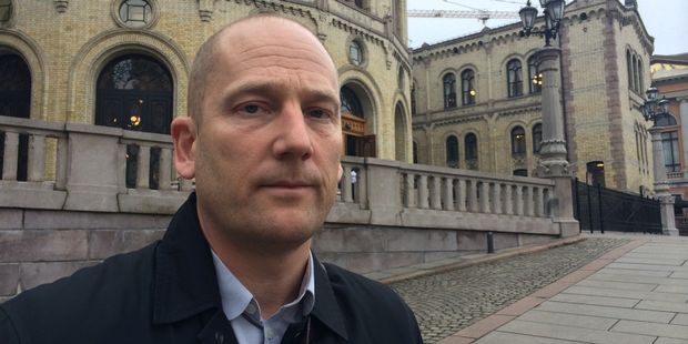 Alvorlig Steffen Handal ser i kameraet med Stortinget i bakgrunnen