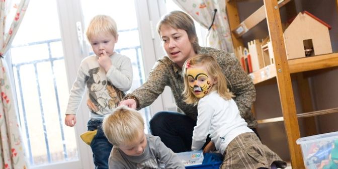 Tre barn og en voksen som leker 