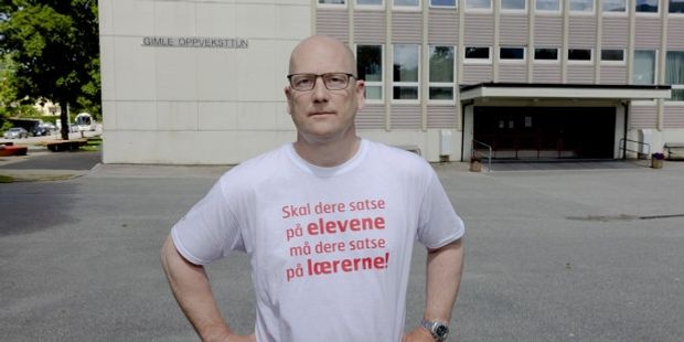 Steffen Handal foran Gimle oppveksttun i Bergen, med t-skjorte med teksten "Skal dere satse på elevene, må dere satse på lærerne".