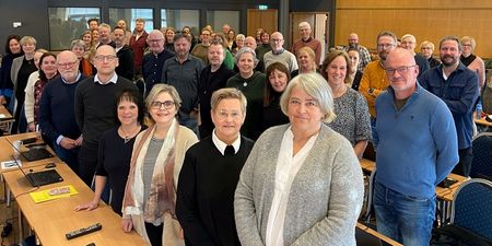 Utdanningsforbundets representantskap står og ser smilende mot fotografen. De er inne i en en konferansesal.