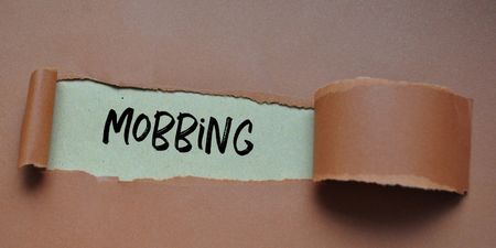 Illustrasjonsfoto der ordet "mobbing" synes under et grått papir. 