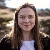 Bilde av blid kvinne med langt brunt hår. Foto.