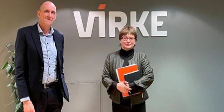 Forhandlingsleder Torgeir Kroken i Virke står sammen med forhandlingsleder Kari Tangen i Unio Virke, foran vegg med logoen til Virke. 