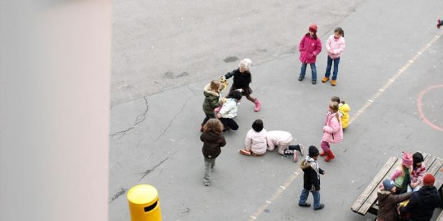 Barneskoleelever som leker i en skolegård. Foto.