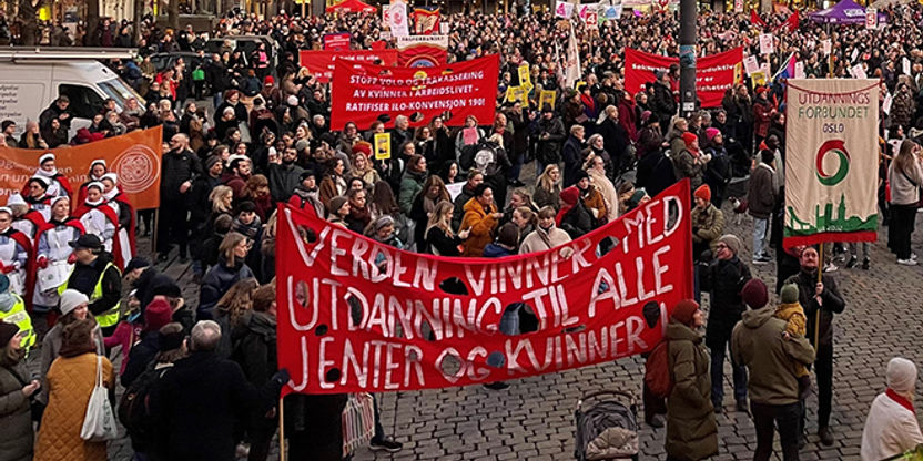 Foto av Youngstorget 8. mars 2022 med mange deltagere, og UDF Oslos fane