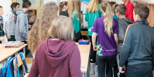 Bilde av mange elever som er på vei ut av klasserommet.