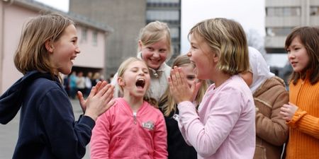 Elever i barneskolen leker og synger i skolegården. Foto.