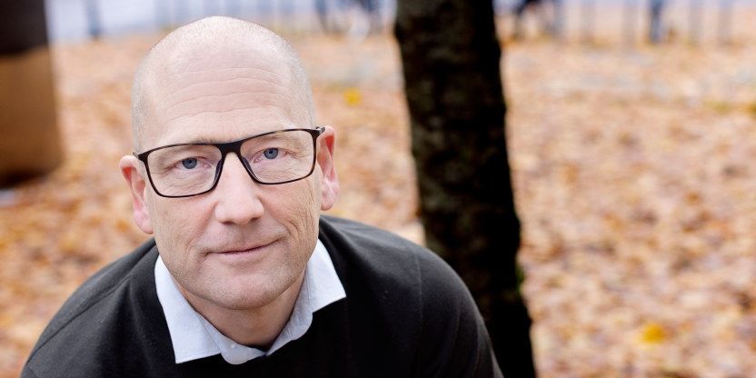 Portrettbilde av Steffen Handal mot en bakgrunn dekket av høstløv