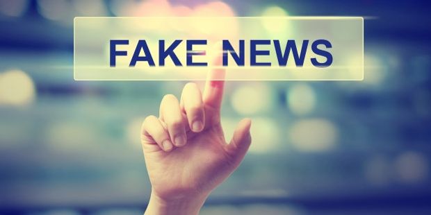 Illustrasjonsbilde av hånd som klikker på et skilt med "Fake news"