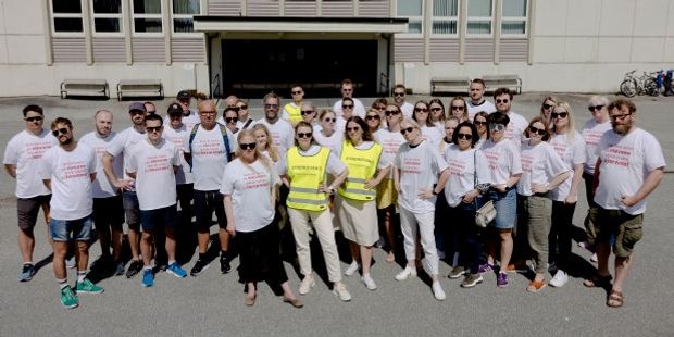 Foto av en gruppe streikende med streike-skjorter og -vester foran Gimle oppveksttun i Bergen.