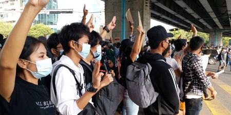 Mennesker i Myanmar protesterer mot militærkuppet ved å holde tre fingre opp i været. Foto.