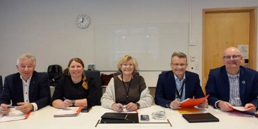 Foto av forhandlerne fra hovedsammenslutningene og statens personaldirektør.