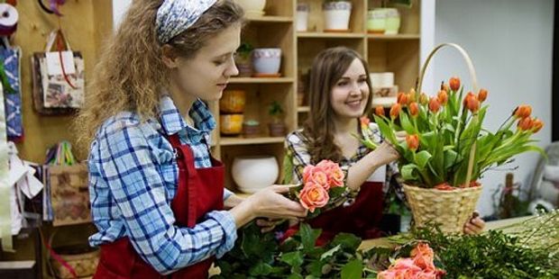 Bilde av en blomsterdekoratør som lager en blomsterbukett. Foto: Illustrasjonsfoto.