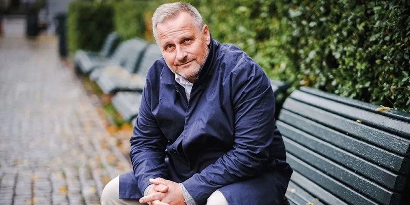 Forhandlingssjef Klemet Rønning-Aaby i Unio sitter ute på en grønn benk med hendene sammen og ser skrått mot kameraet.