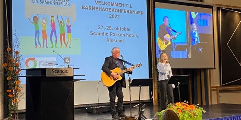 Kulturelt innslag med en kvinne på vokal og en mann på gitar.