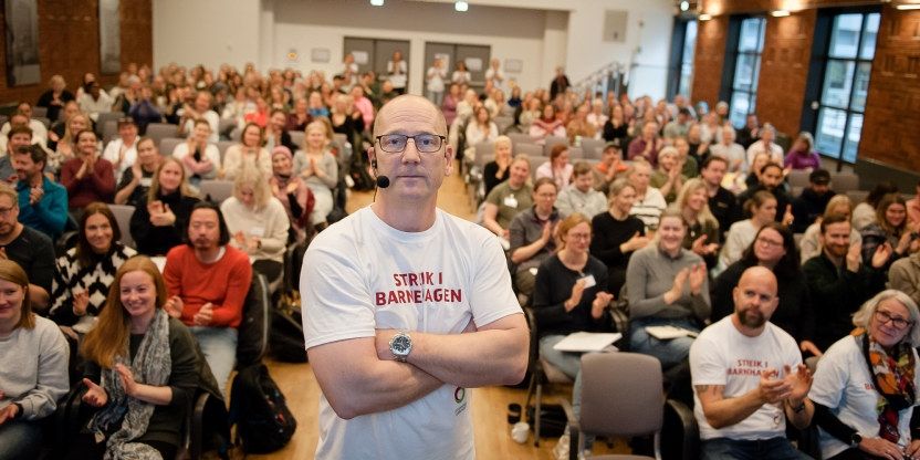 Steffen Handal står foran streikende i Ingeniørenes hus i Oslo.