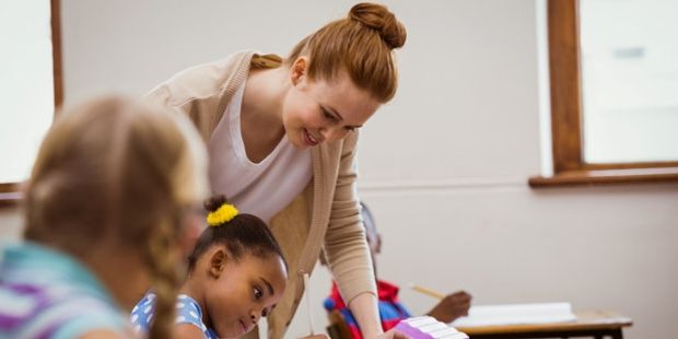 Kvinnelig lærer hjelper elev