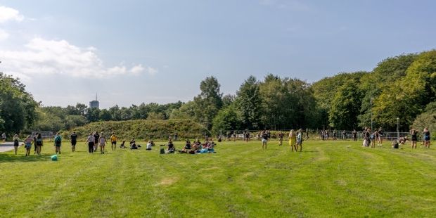 Mennesker på en gresslette en fin sommerdag.