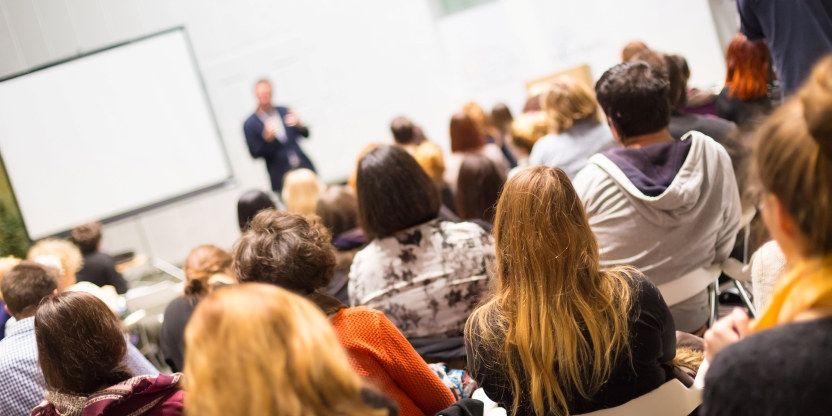 Bildet viser en undervisningssituasjon i et klasserom der studentene sitter med ryggen til oss og ser på en som underviser.