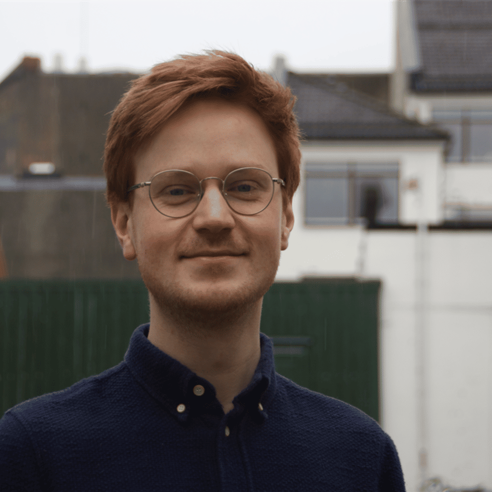 Bilde av Mathias. Smilende mann med briller.