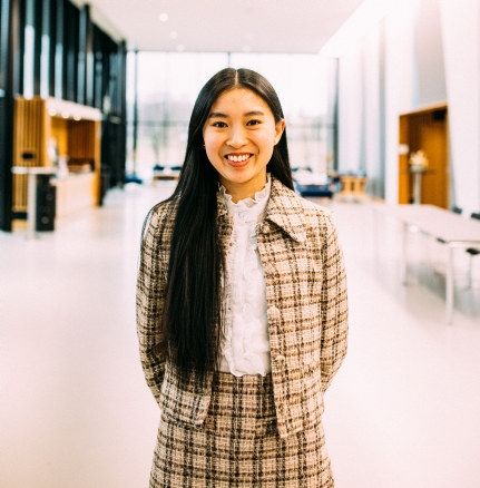 Portrett av en blid kvinne i midten av 20-årene med sort hår. Foto.