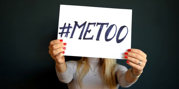 Kvinne som holder plakat med #metoo foran ansiktet. Foto.