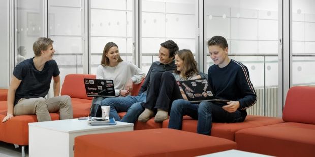 En gruppe ungdommer sitter i en sofa. Foto.
