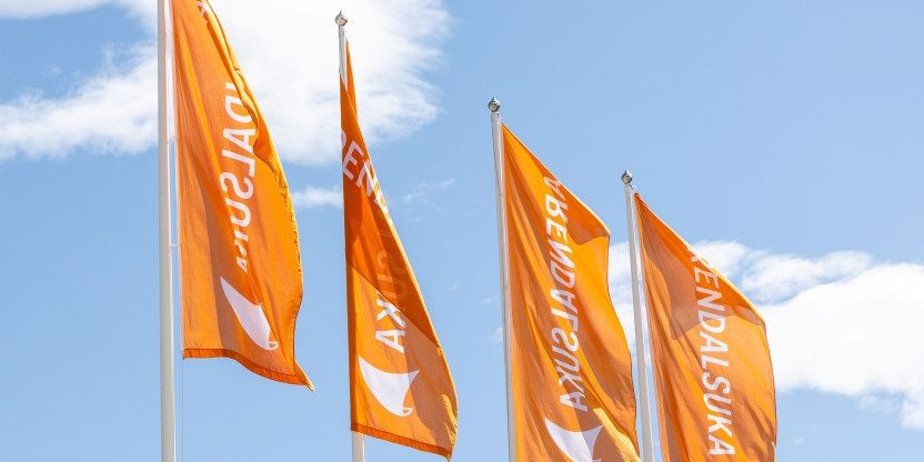 Fire oransje flagg mot blå himmel med påskriften Arendalsuka