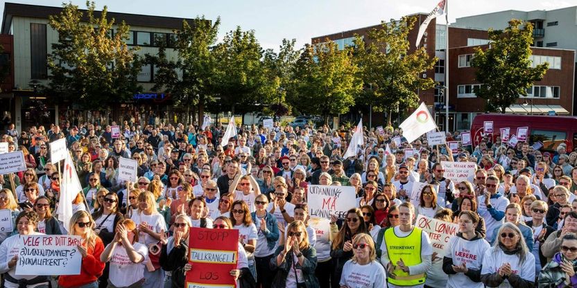 Mer enn 500 mennesker samlet på torget i Stjørdal, noen kledd i streike-t-skjorter, noen med faner og plakater.