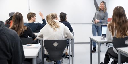 En kvinnelig lærer som underviser i et klasserom. Foto.