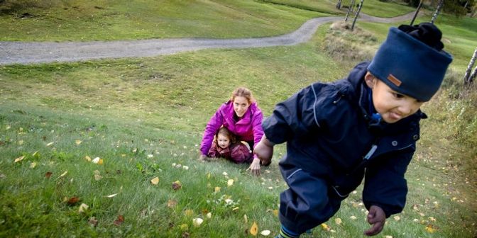 Barn som går opp en gresslagt bakke