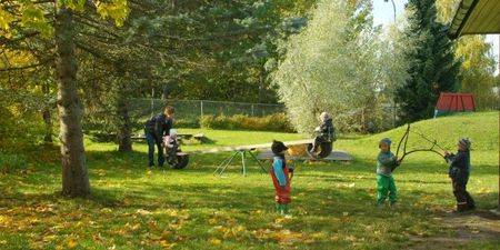 Barn som leker ute i en stor park. Foto.