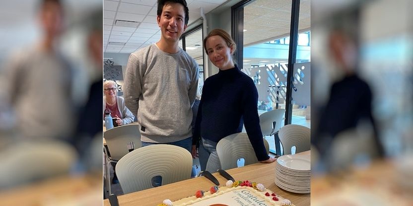Lars Tsujimoto Frengstad og Maya Rønning Lindseth står og ser på en stor kake med påskriften "Gratulerer til medlem nr. 16500 i Trøndelag"