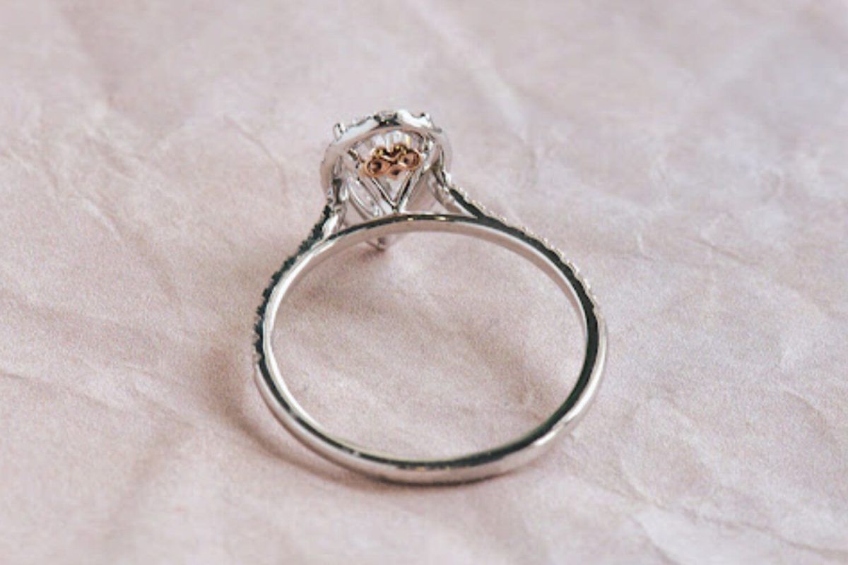 A pear-cut diamond ring on 14k white gold featuring a custom infinity on the heart symbol in the under gallery.