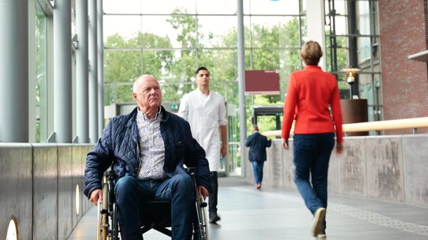 man in rolstoel in ziekenhuis