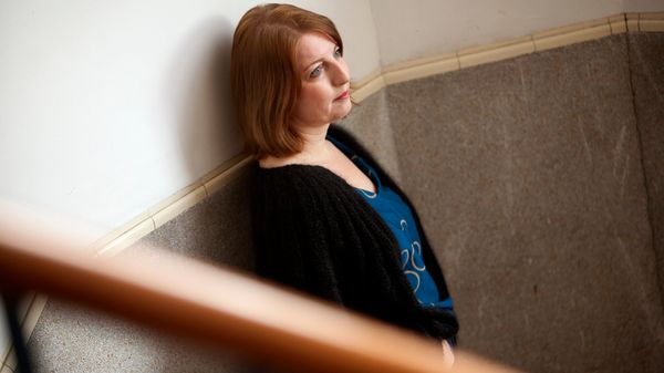 Vrouw staat in trappenhuis tegen muur