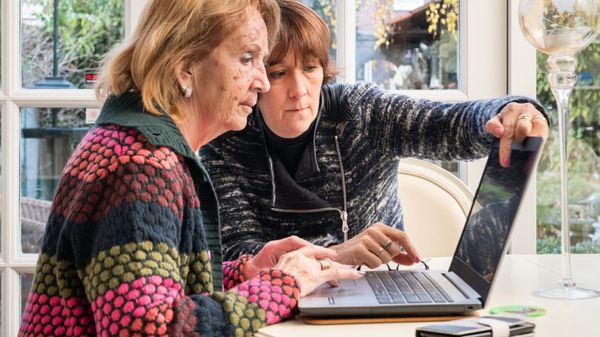 Twee vrouwen achter laptop aan tafel