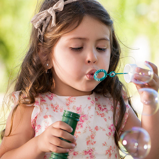 little girl blowing bubbles