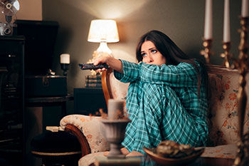 Woman watching TV in pajamas