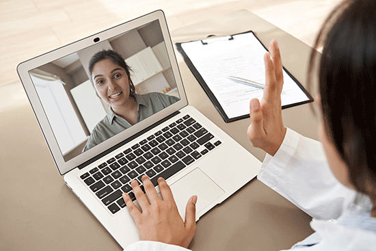 Doctor talking to rep via laptop virtual conference 