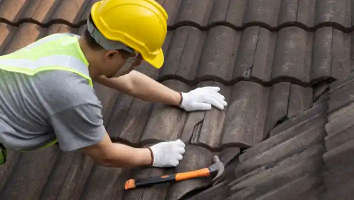 Two workers installing rooftop solar panels safely equipped with PPE and tools.