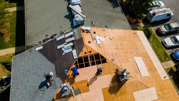 Aerial view of a worker inspecting solar panels on a rooftop, promoting renewable energy.