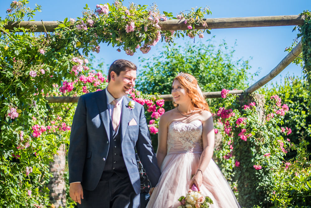 Bride and groom walking through flower gardens, Ripley Castle weddings, Yorkshire wedding photographers