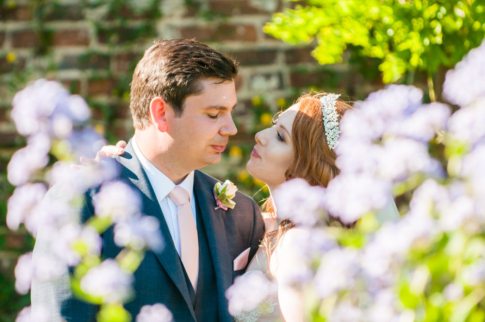 Bride and groom looking at each other through flowers, Ripley Castle weddings, Yorkshire wedding photographers